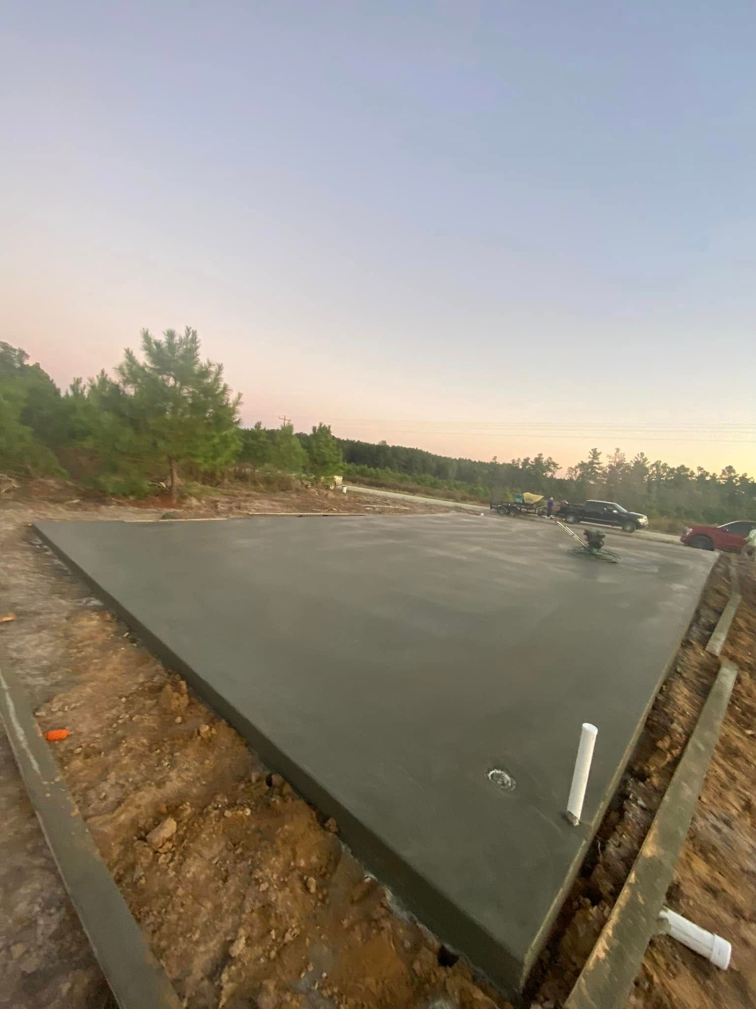 A large concrete slab is sitting on top of a dirt field.