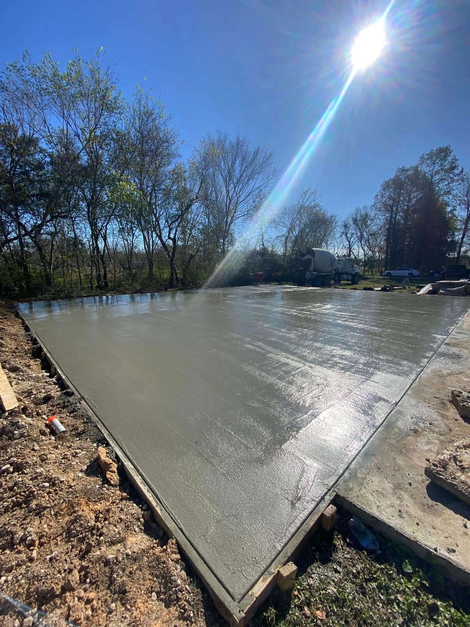 The sun is shining through the trees on a concrete surface.