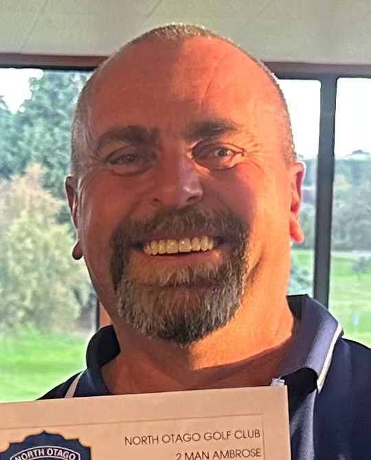 A man with a beard is holding a certificate from the north otago golf club