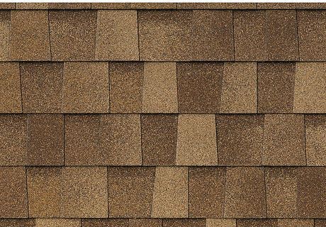 A close up of a roof with brown shingles on it.