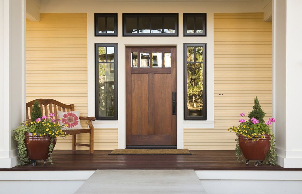 The Front Of A House With A Wooden Door And A Bench — Ace Glass & Aluminium In Maclean, NSW