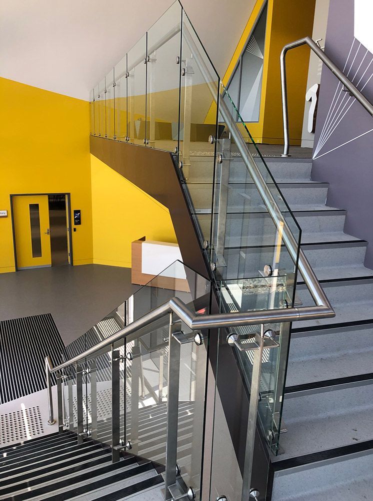 A Staircase With A Glass Railing And Yellow Walls — Ace Glass & Aluminium In Grafton, NSW
