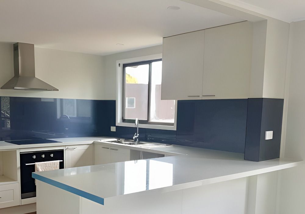 Modern White Kitchen with Navy Blue Backsplash and Aluminum Window — Ace Glass & Aluminium In Grafton, NSW