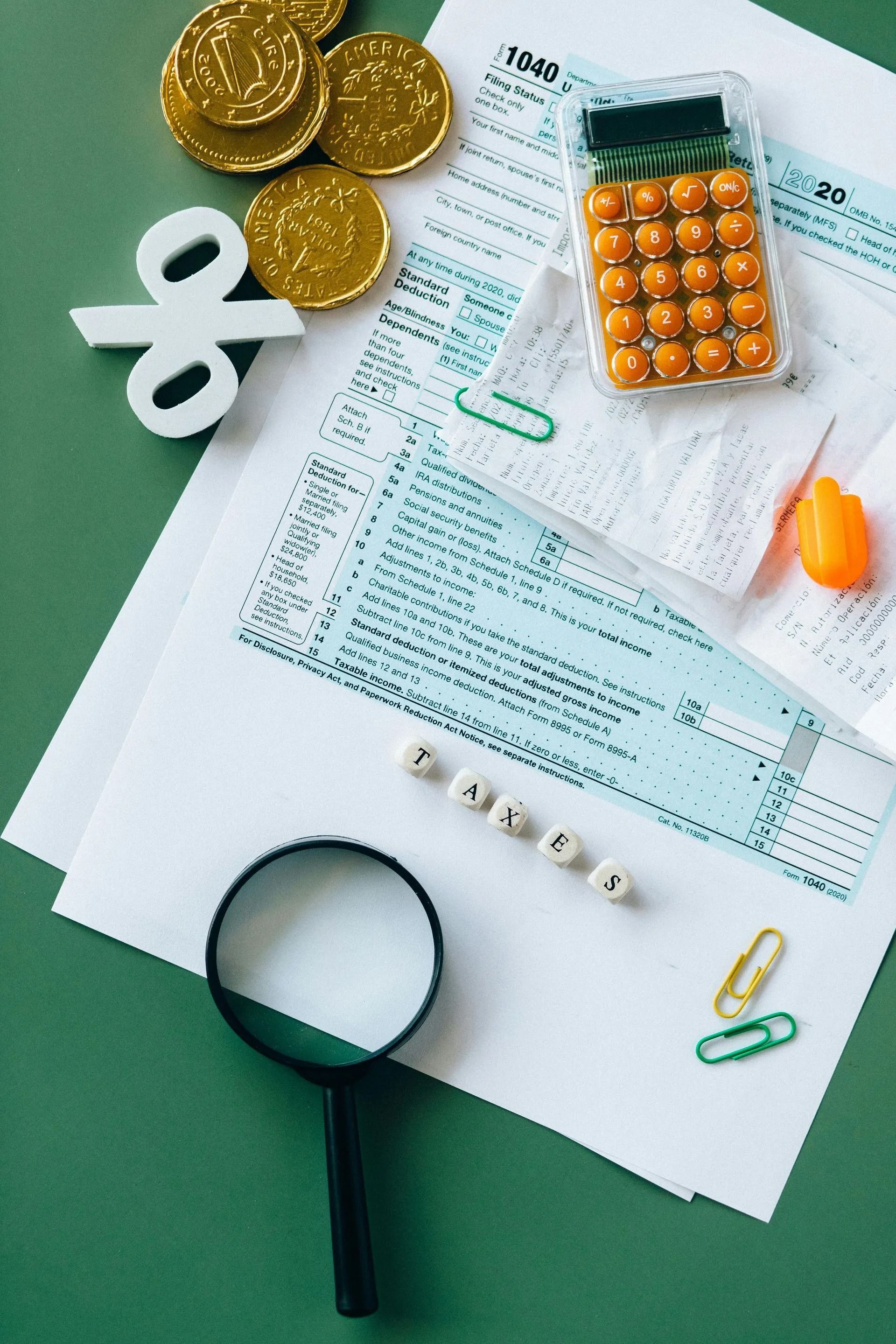 Fatture di medicinali e monete con calcolatrice, lente d'ingrandimento e pillole su una scrivania bianca