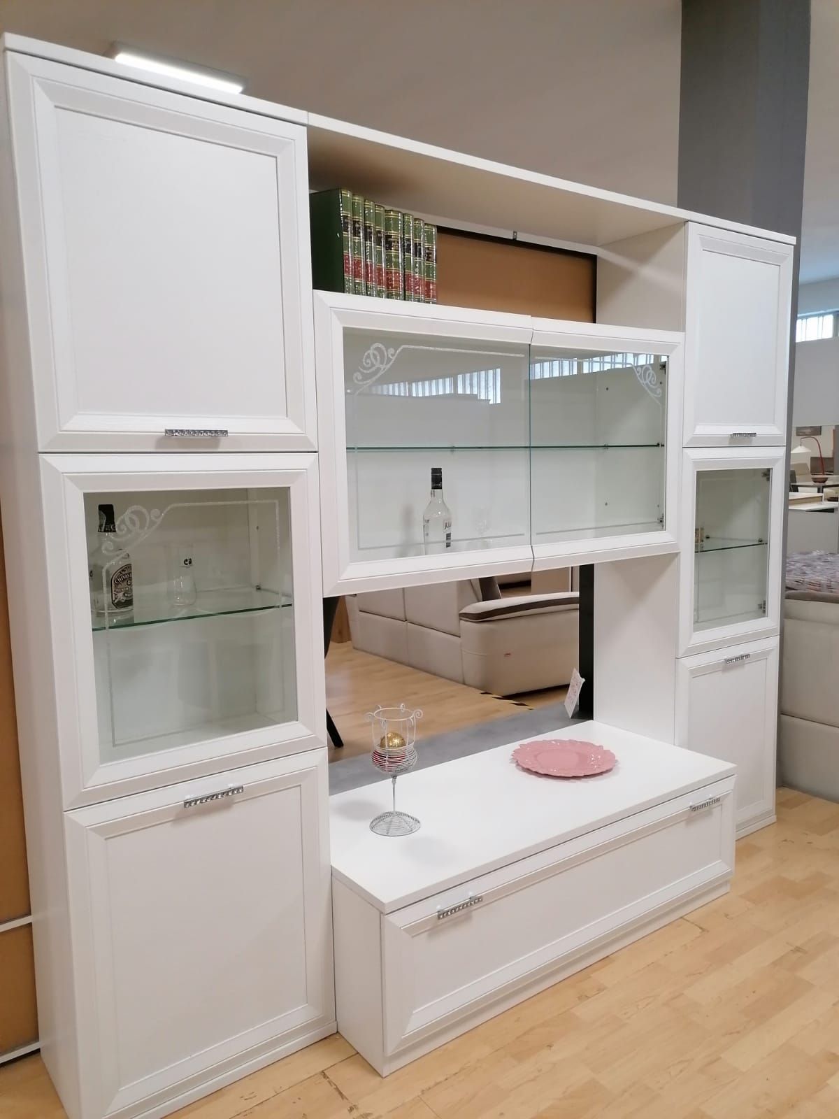 Un soggiorno con mobili bianchi e ripiani in vetro in un negozio.