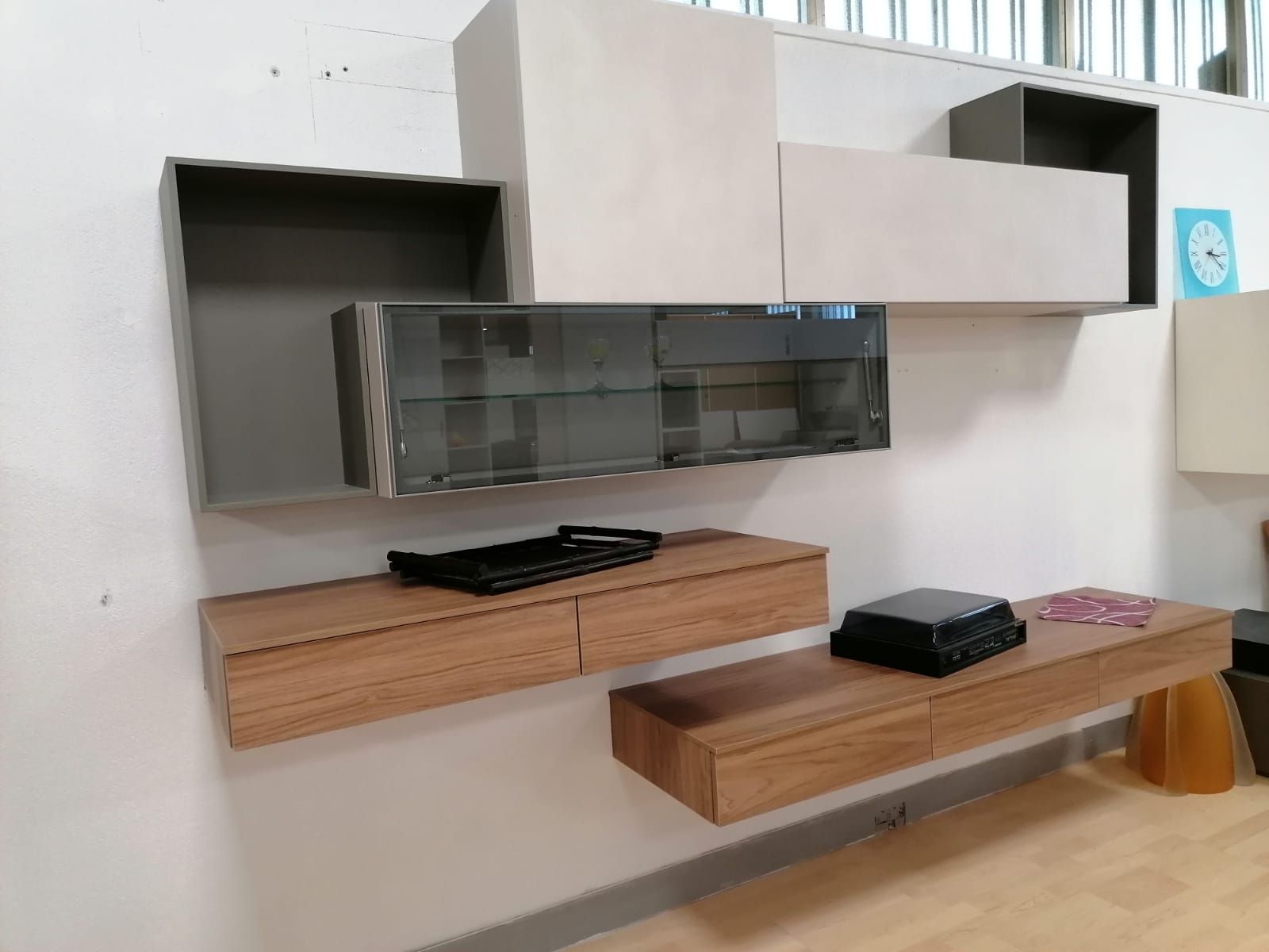 Un soggiorno con molti scaffali e cassetti sul muro.