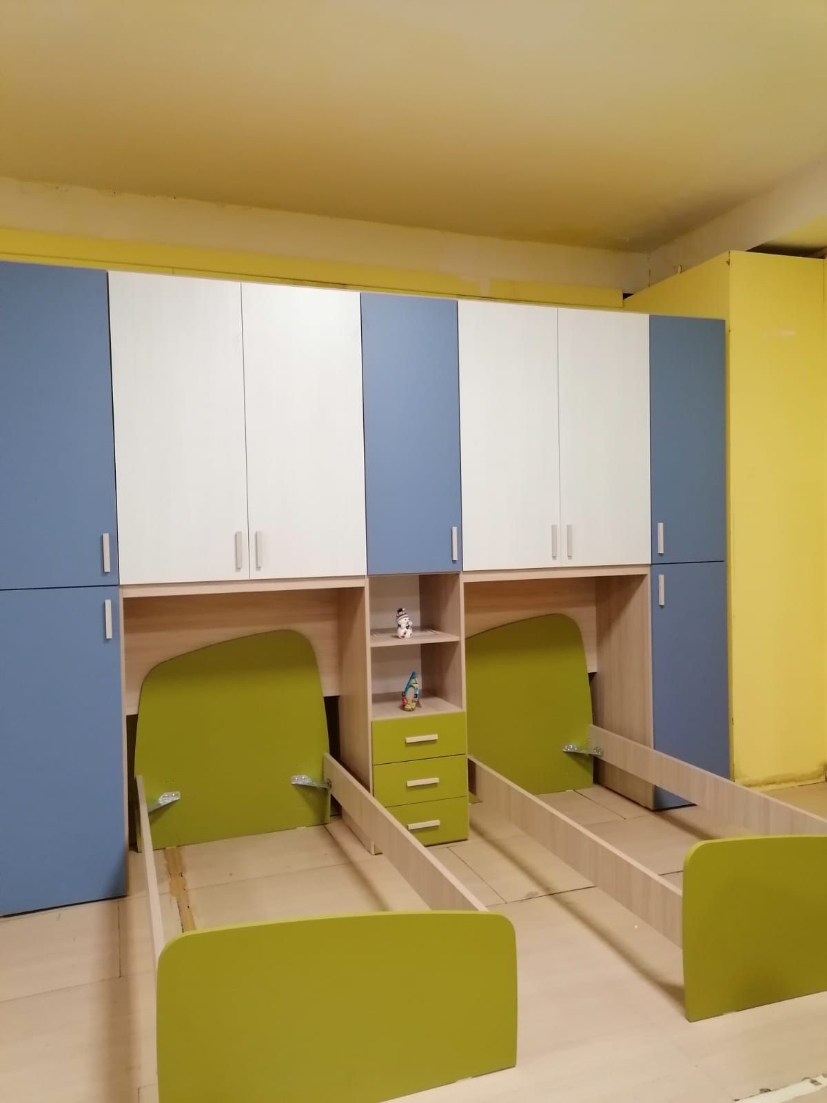 Una camera da letto con due letti e armadi blu e bianchi