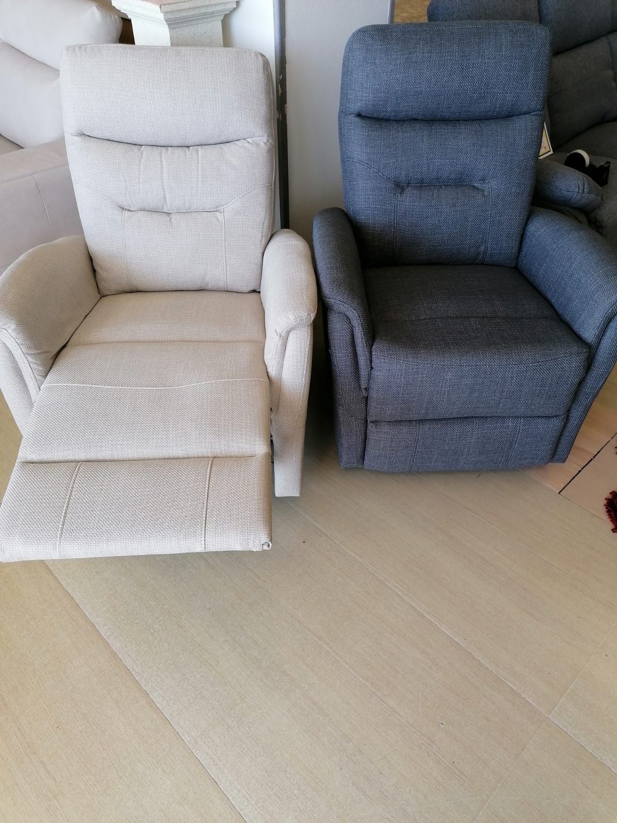 Due poltrone reclinabili sono posizionate una accanto all'altra su un pavimento in legno.