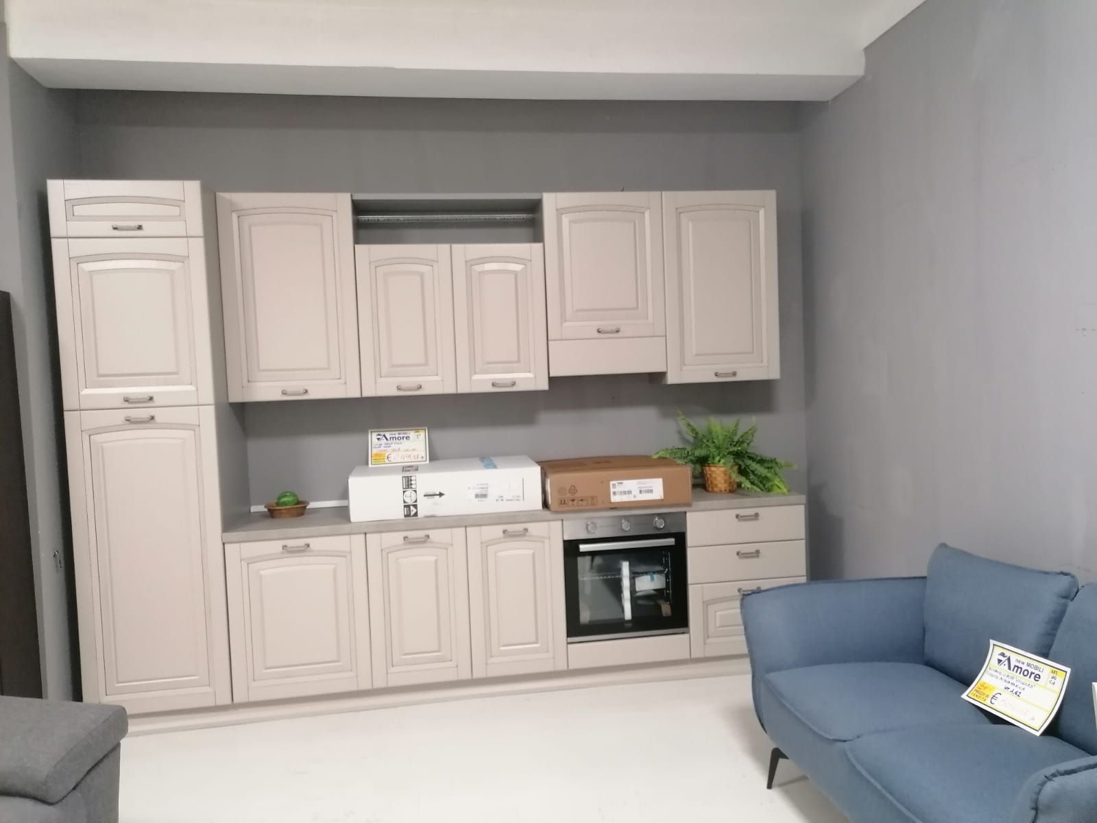 Un soggiorno con un divano e una cucina con molti mobili.