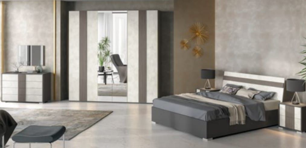 Una camera da letto con un letto, una cassettiera, un comodino, uno specchio e un armadio.