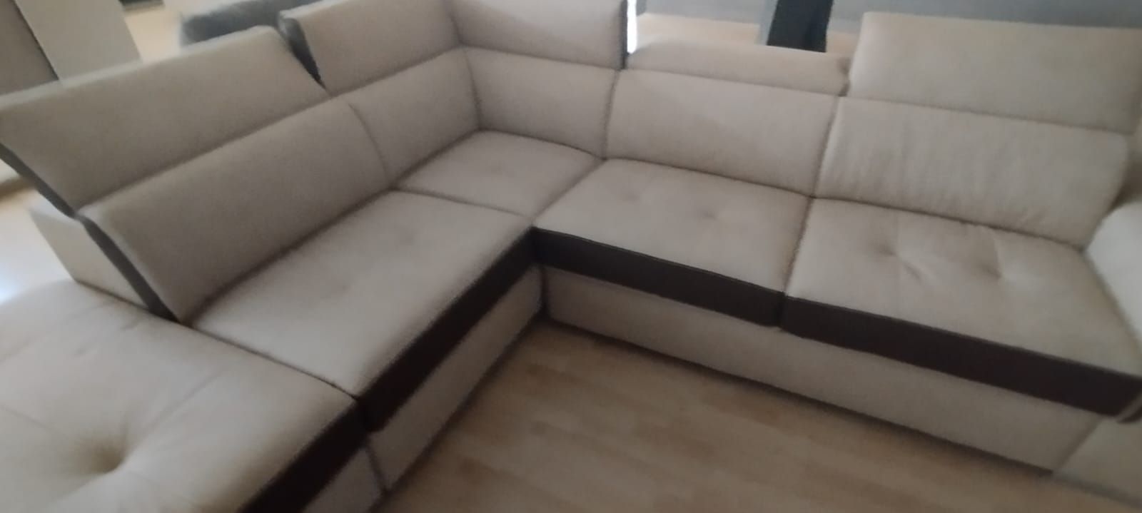 Un divano componibile bianco con finiture nere è posizionato nel soggiorno.