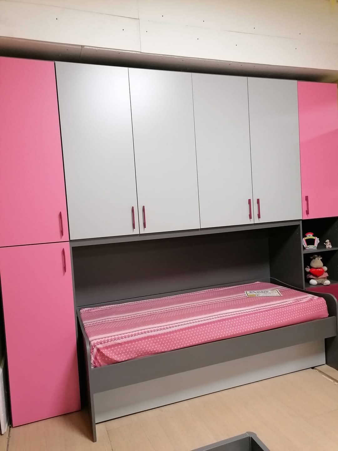 Una camera da letto con armadi rosa e un letto rosa