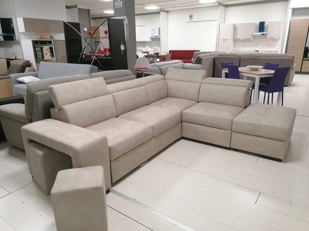 Un grande divano componibile è posizionato in una stanza insieme ad altri mobili.