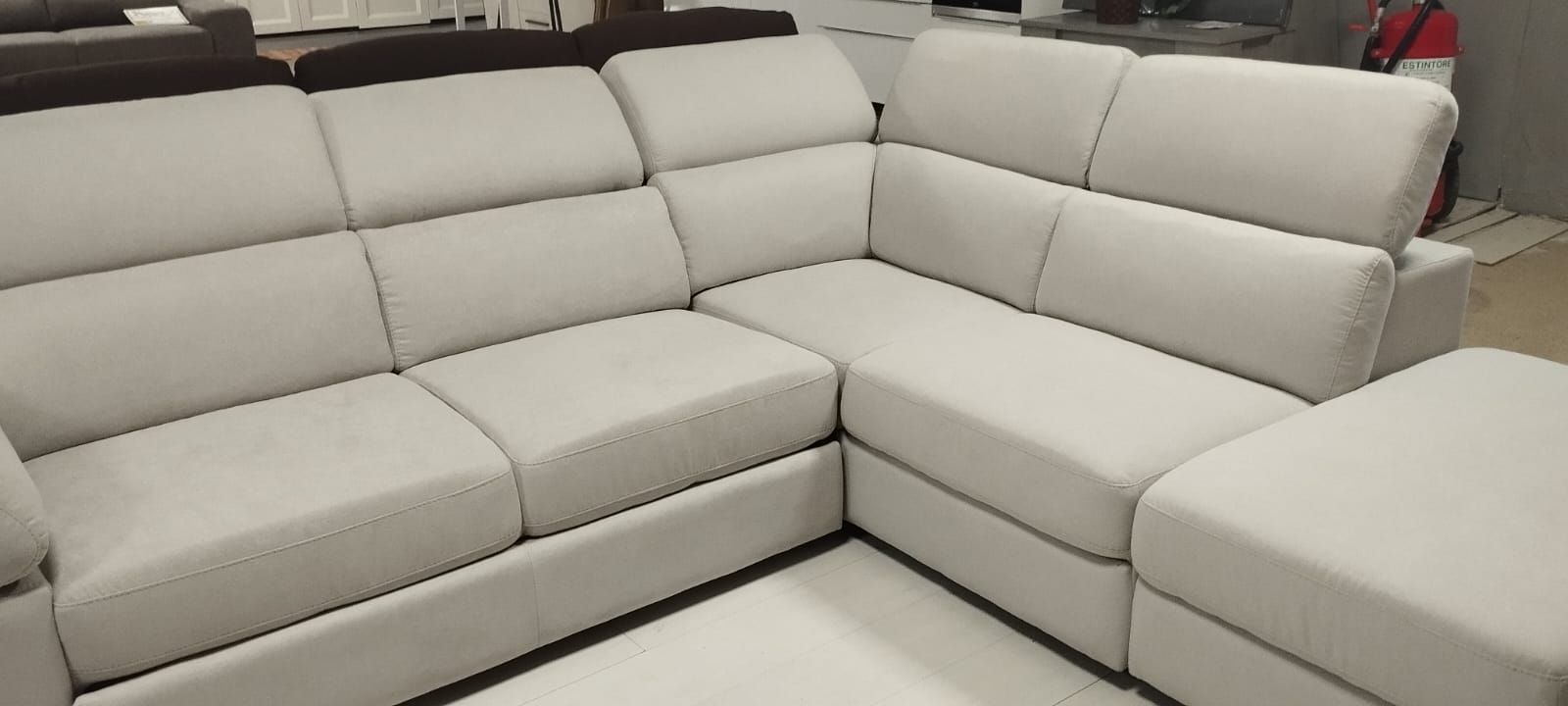 Un divano componibile bianco con una chaise longue in un soggiorno.