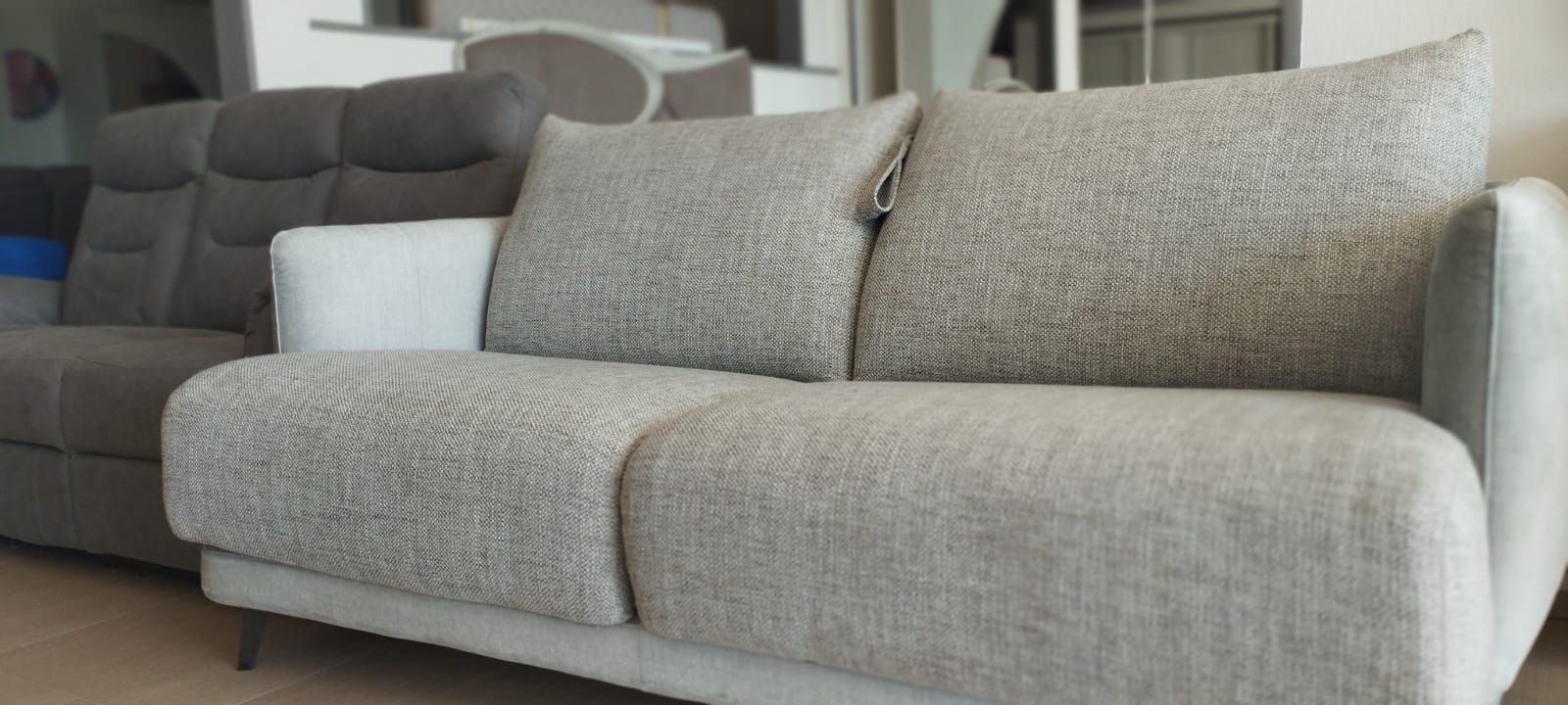 In soggiorno c'è un divano con due cuscini sopra.