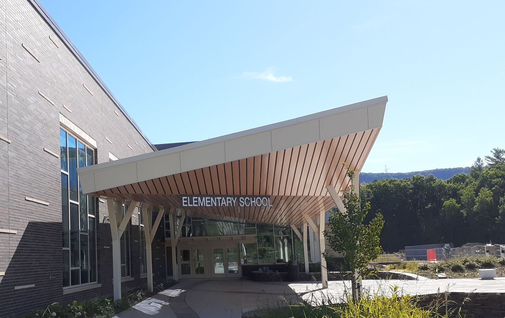 A brick building with a wooden canopy over the entrance