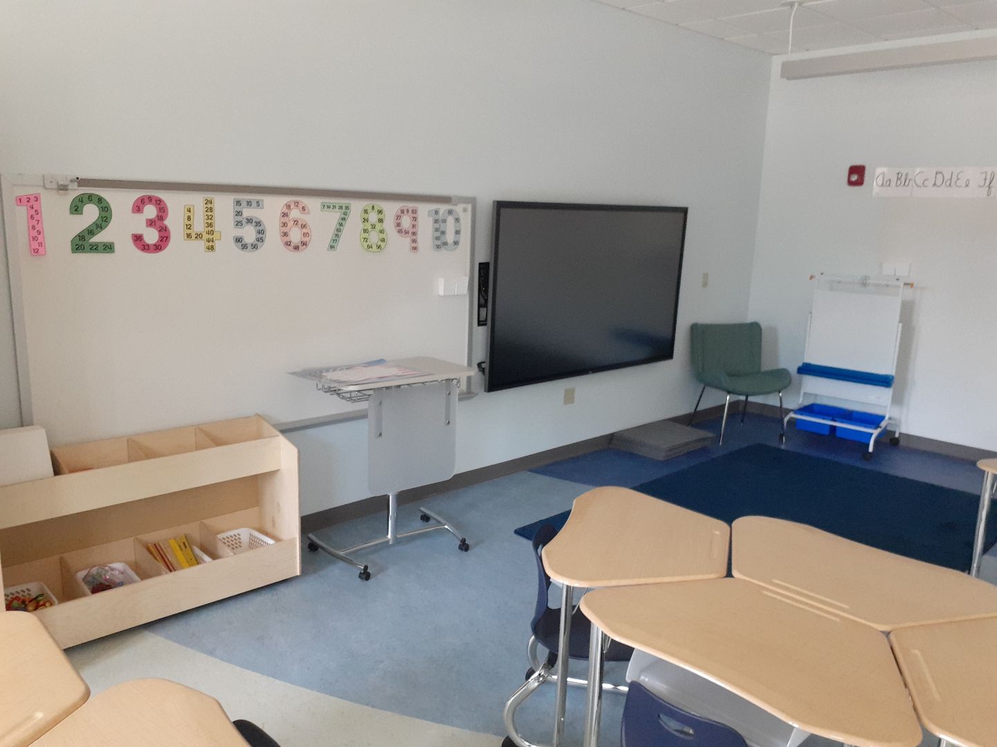 A classroom with a white board with numbers on it