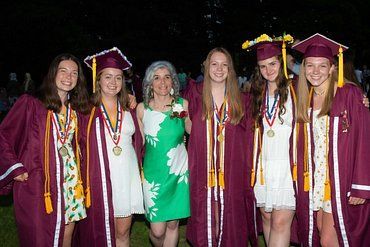 A group of female graduates are posing for a picture with their mother.