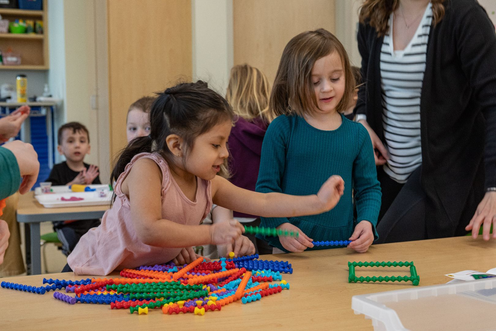 A group of children are playing with colorful blocks on a table