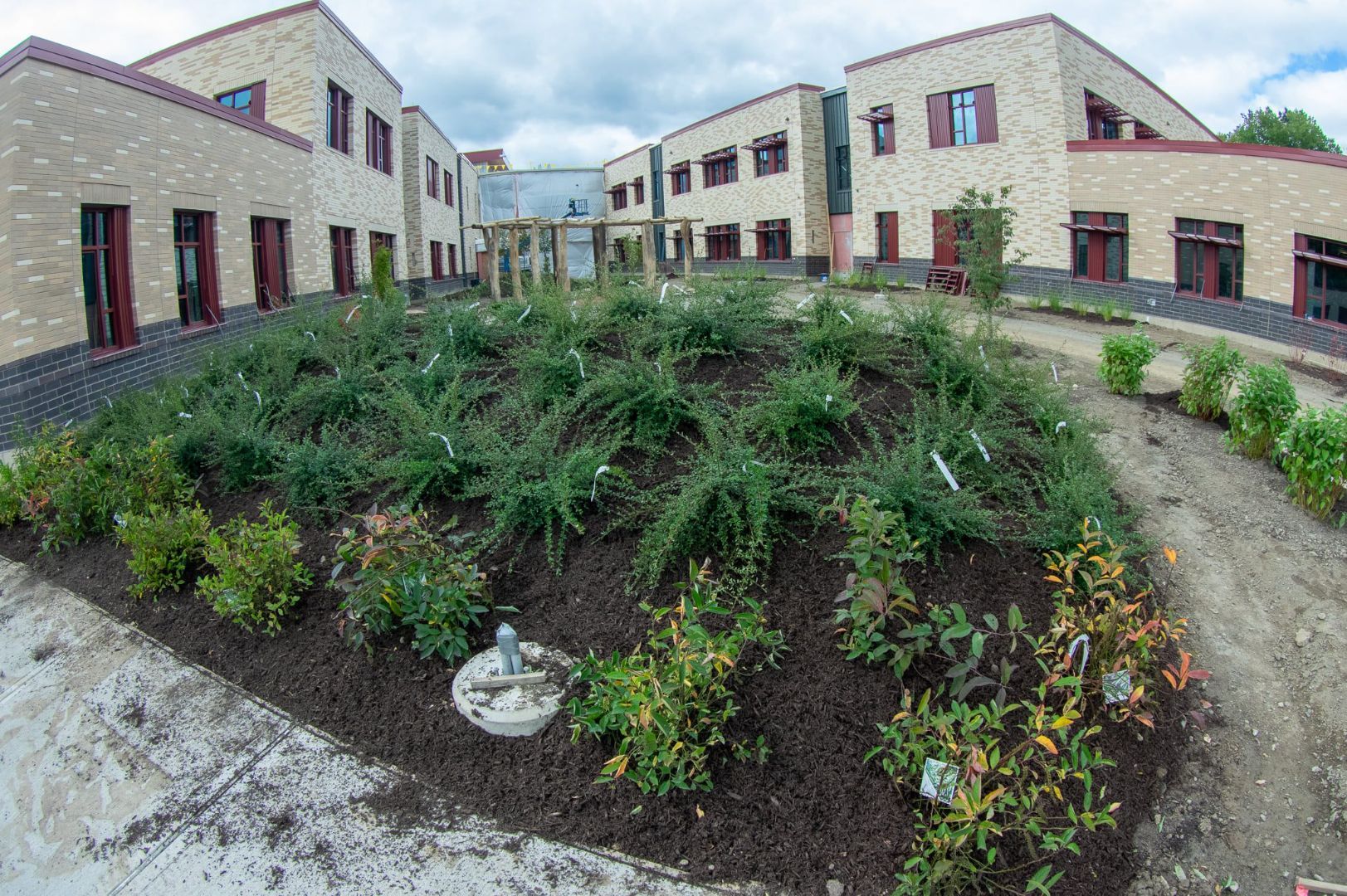 A large brick building with a garden in front of it