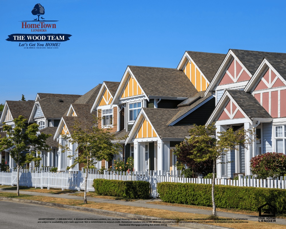 A row of houses with a white picket fence in a residential neighborhood.