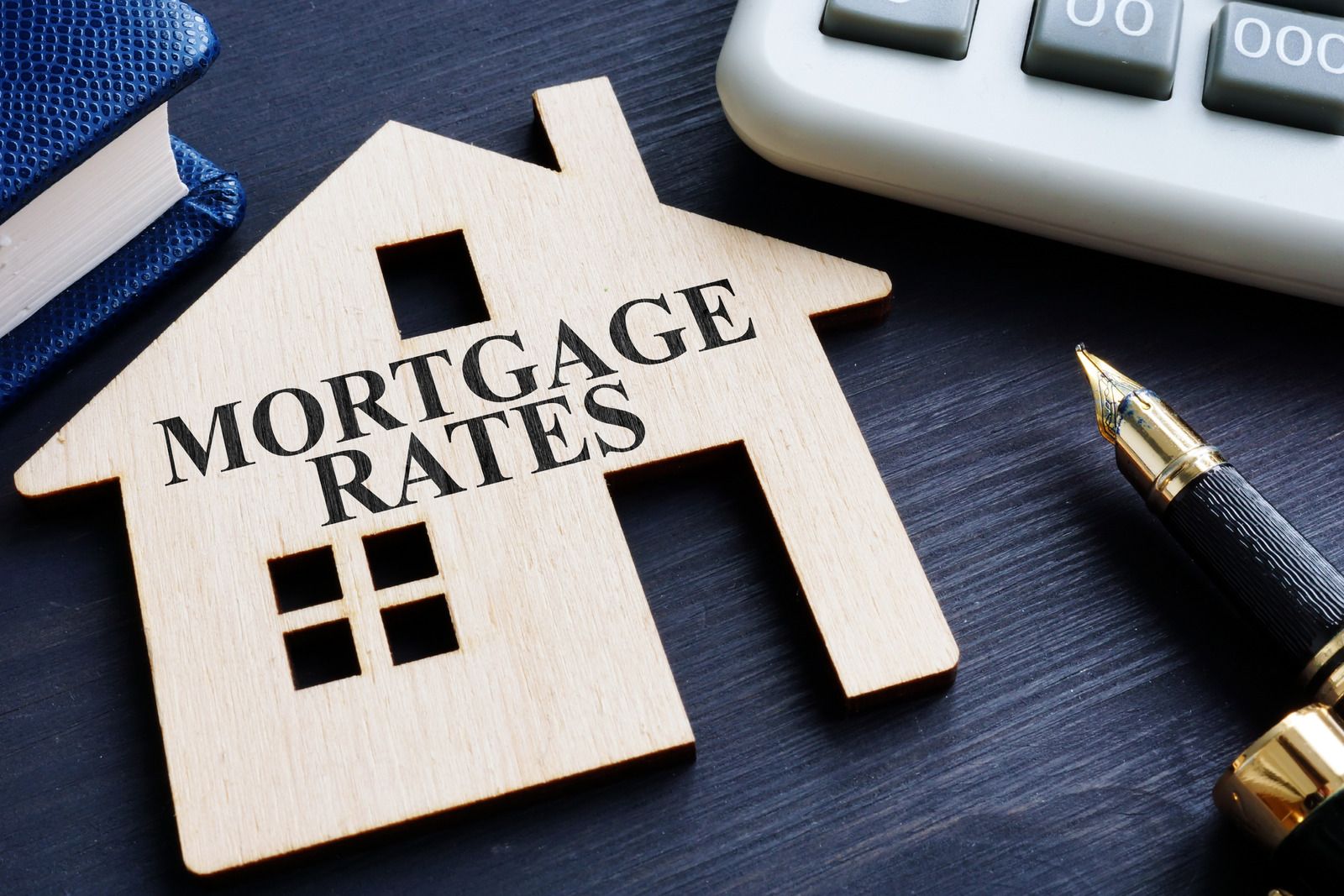 A wooden house with the words `` mortgage rates '' written on it.