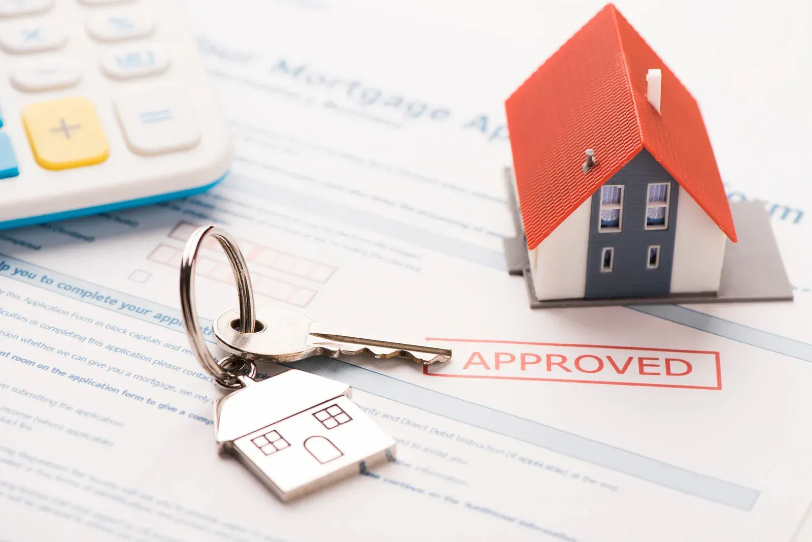 A mortgage approval form with a key and a model house