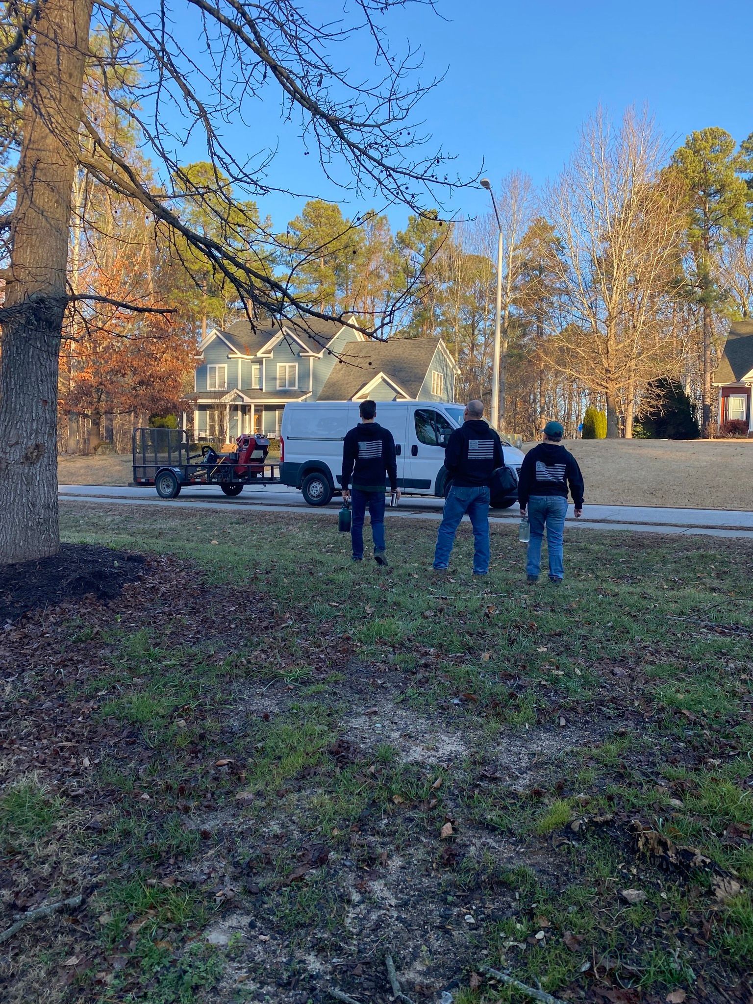 A group of men are standing in front of a white van.