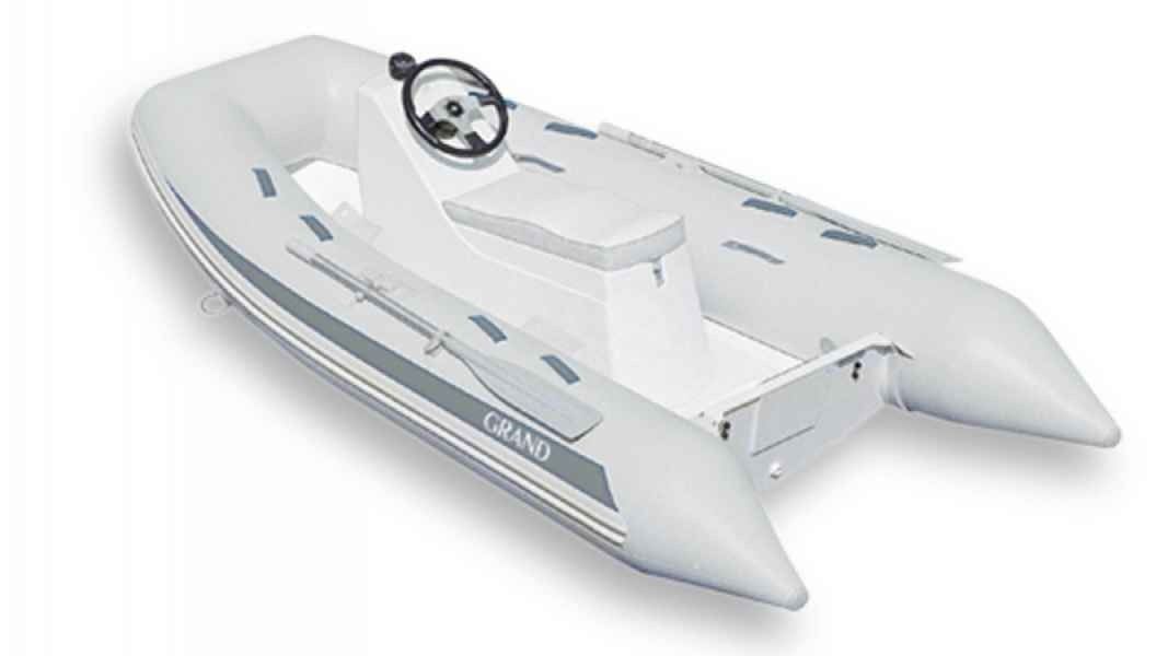 White inflatable motorboat with steering console on a plain background