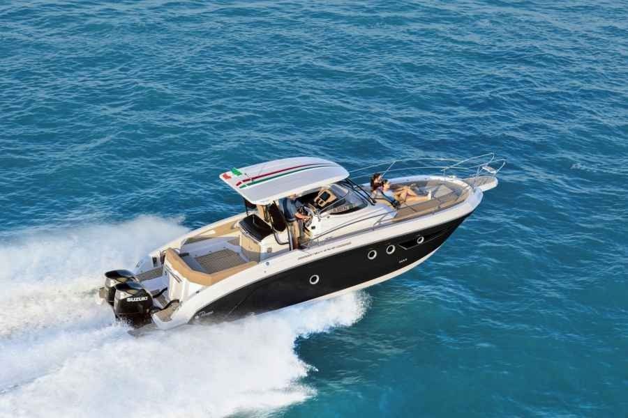 Luxury speedboat cruising on blue water, leaving a white wake behind