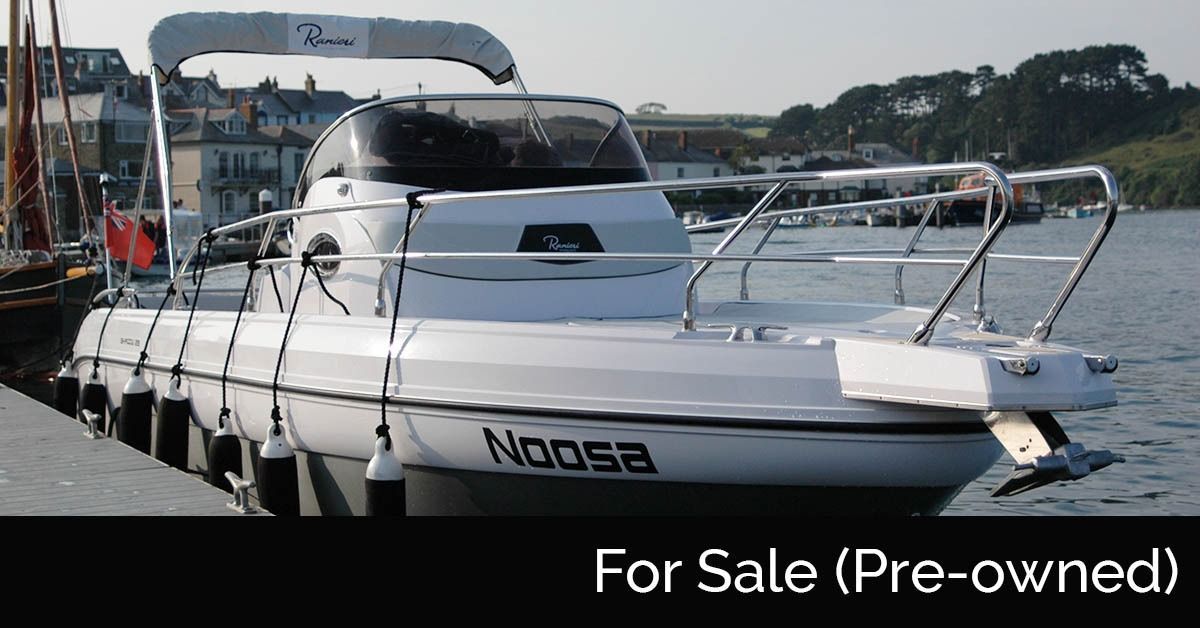 White motorboat docked at a marina with a 