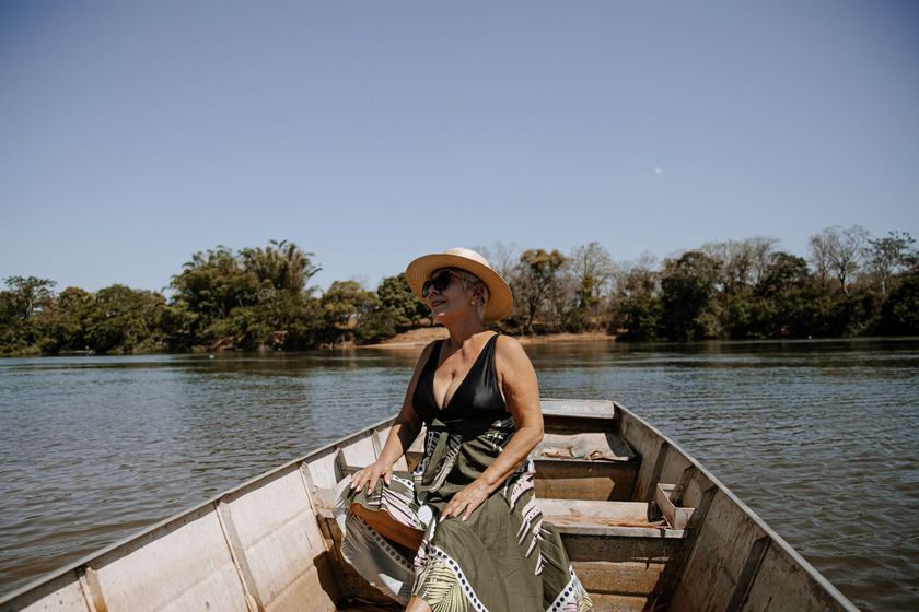 Uma mulher está sentada em um barco em um lago.