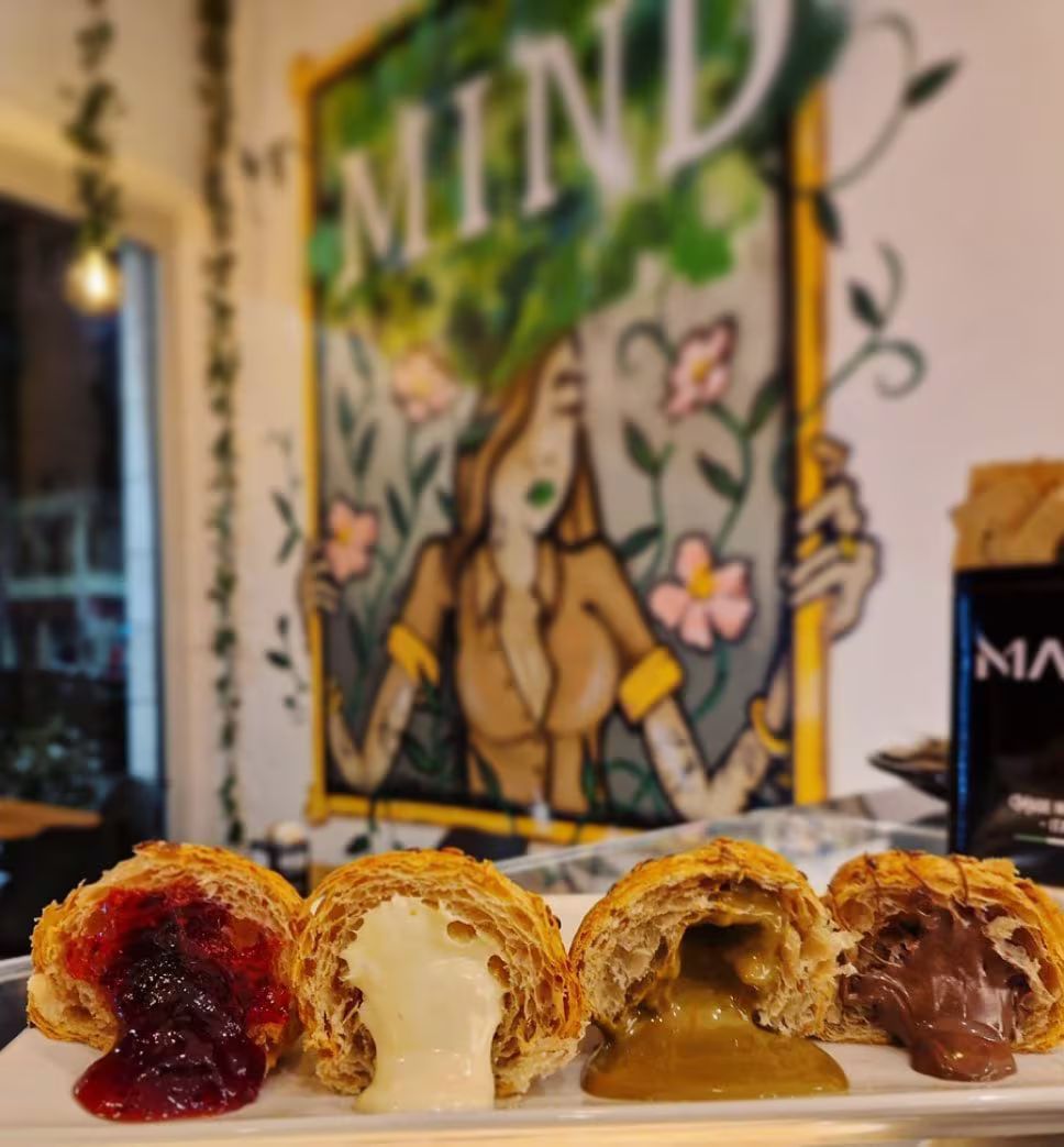 Primo piano di quattro pasticcini ripieni davanti a un murale raffigurante una donna e la parola