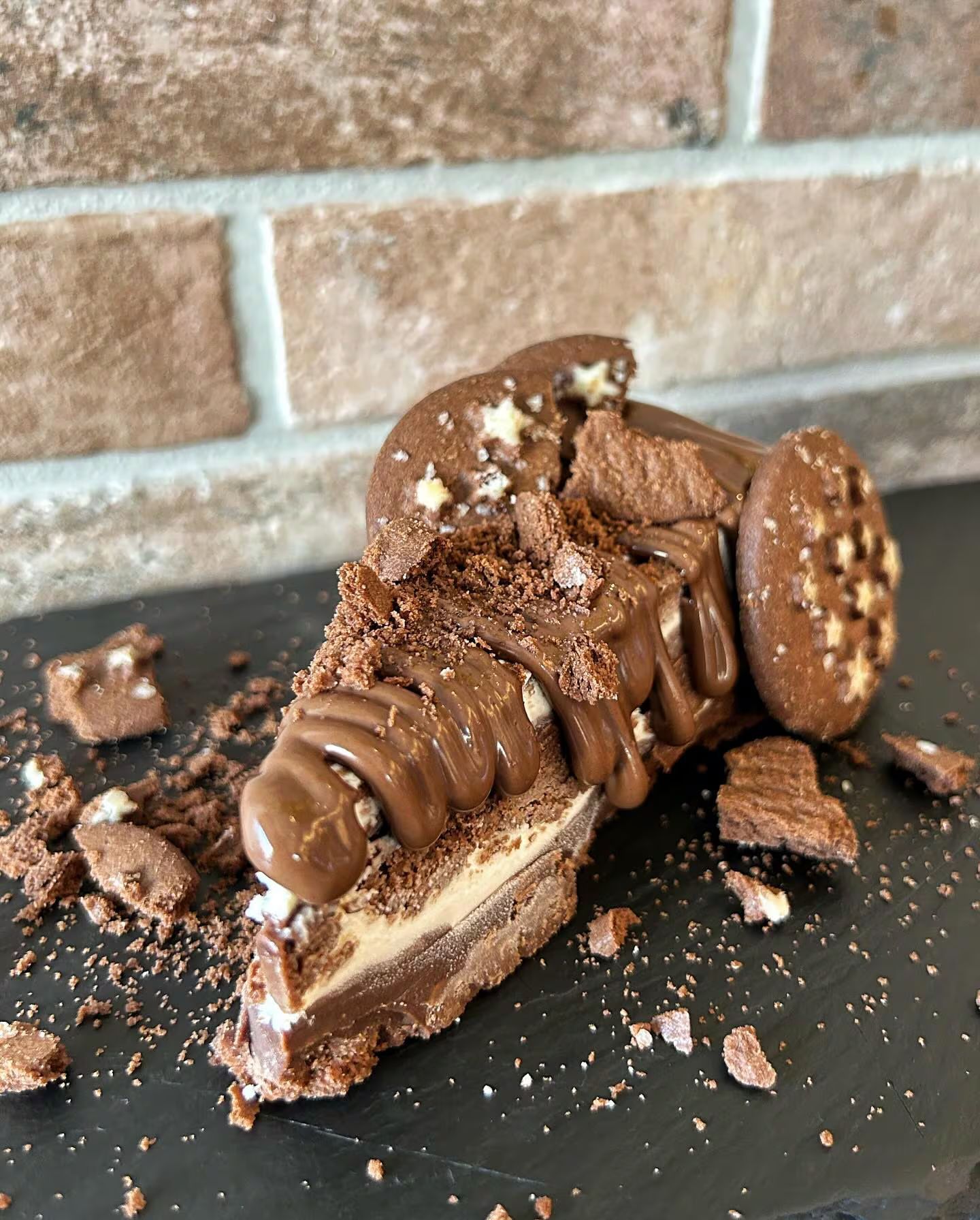 Fetta di cheesecake al cioccolato con biscotti e gocce di cioccolato.