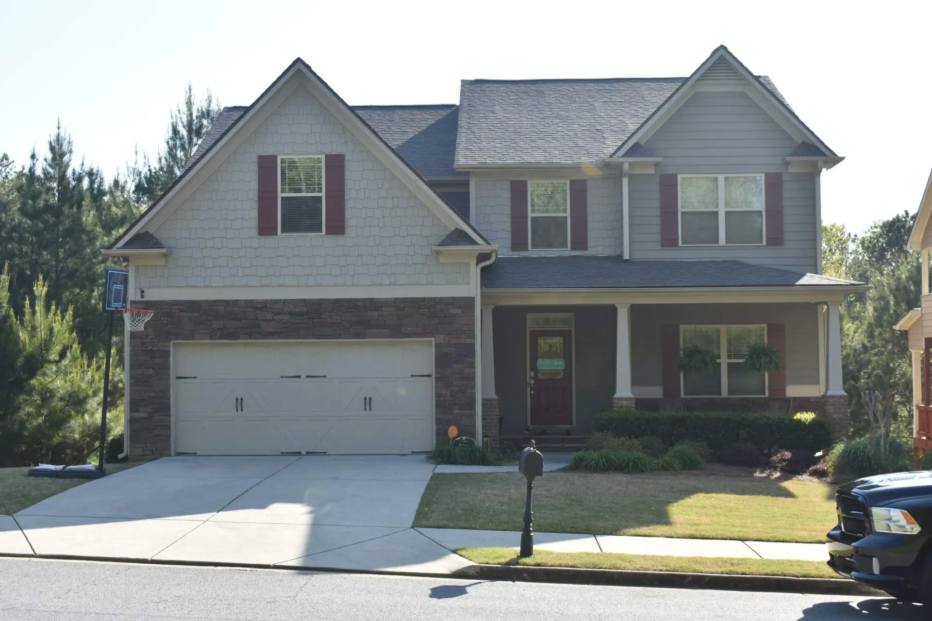 Two-story house with a brick and siding exterior, a two-car garage, and a front porch.