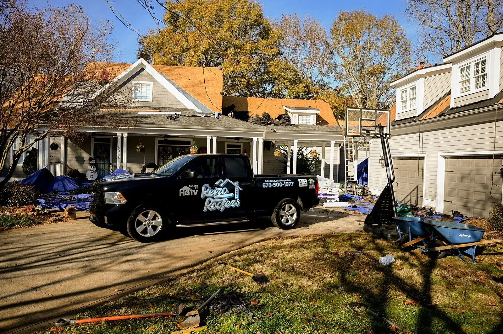 Black truck parked in front of a house under construction with a fall setting.
