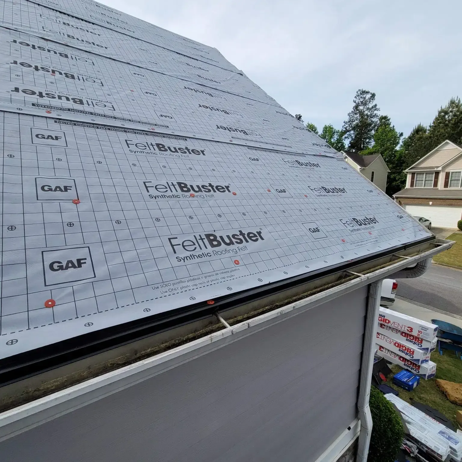 Roof with GAF FeltBuster underlayment, part of a house under construction; daytime.