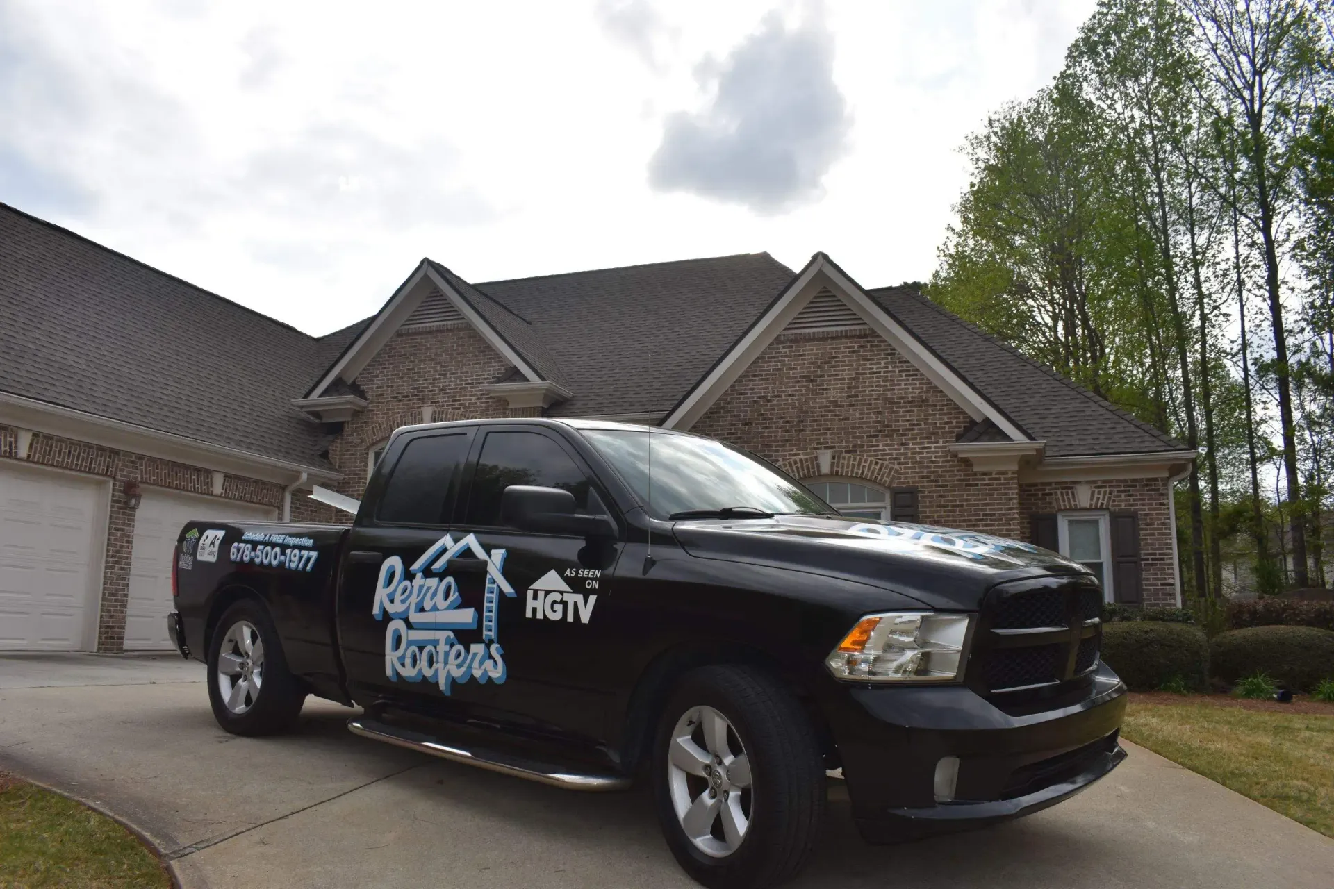 Black pickup truck parked in front of a house with a garage. 
