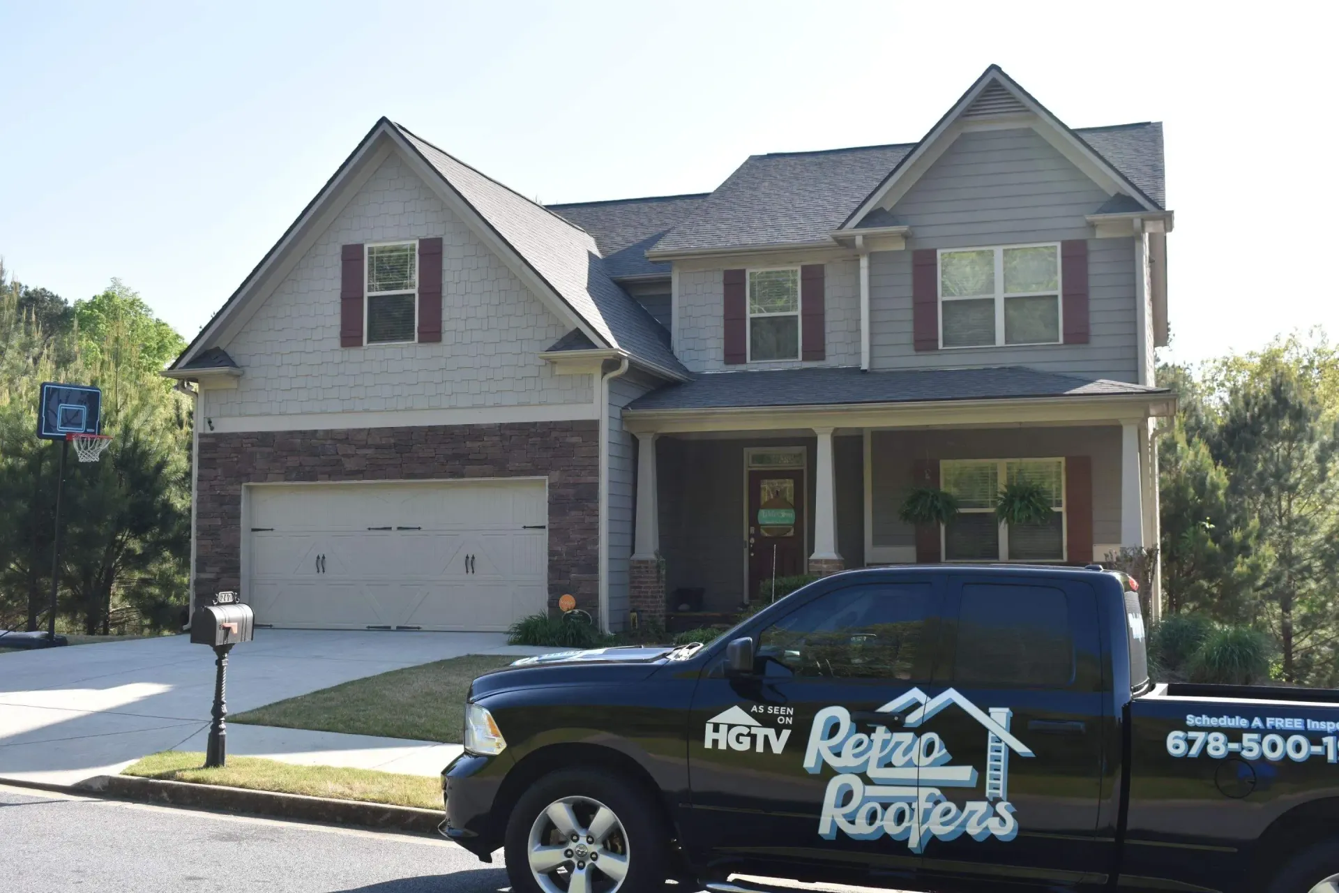 A two-story house with a dark truck in front; the truck has 