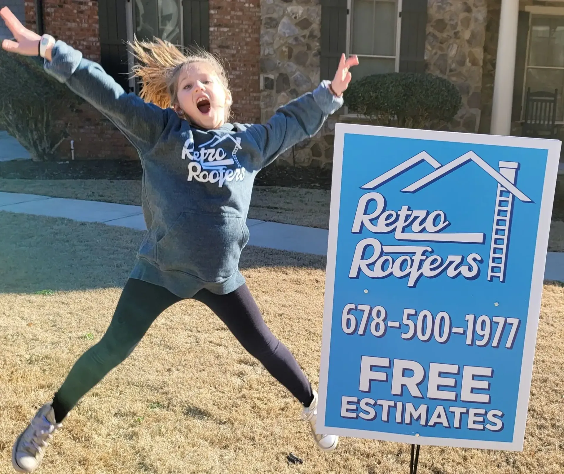 A girl jumps excitedly next to a Retro Roofers sign.