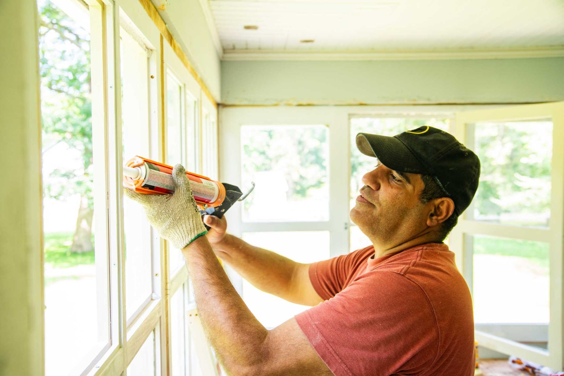 A window contractor using sealant on a window. A window contractor using sealant on a window.