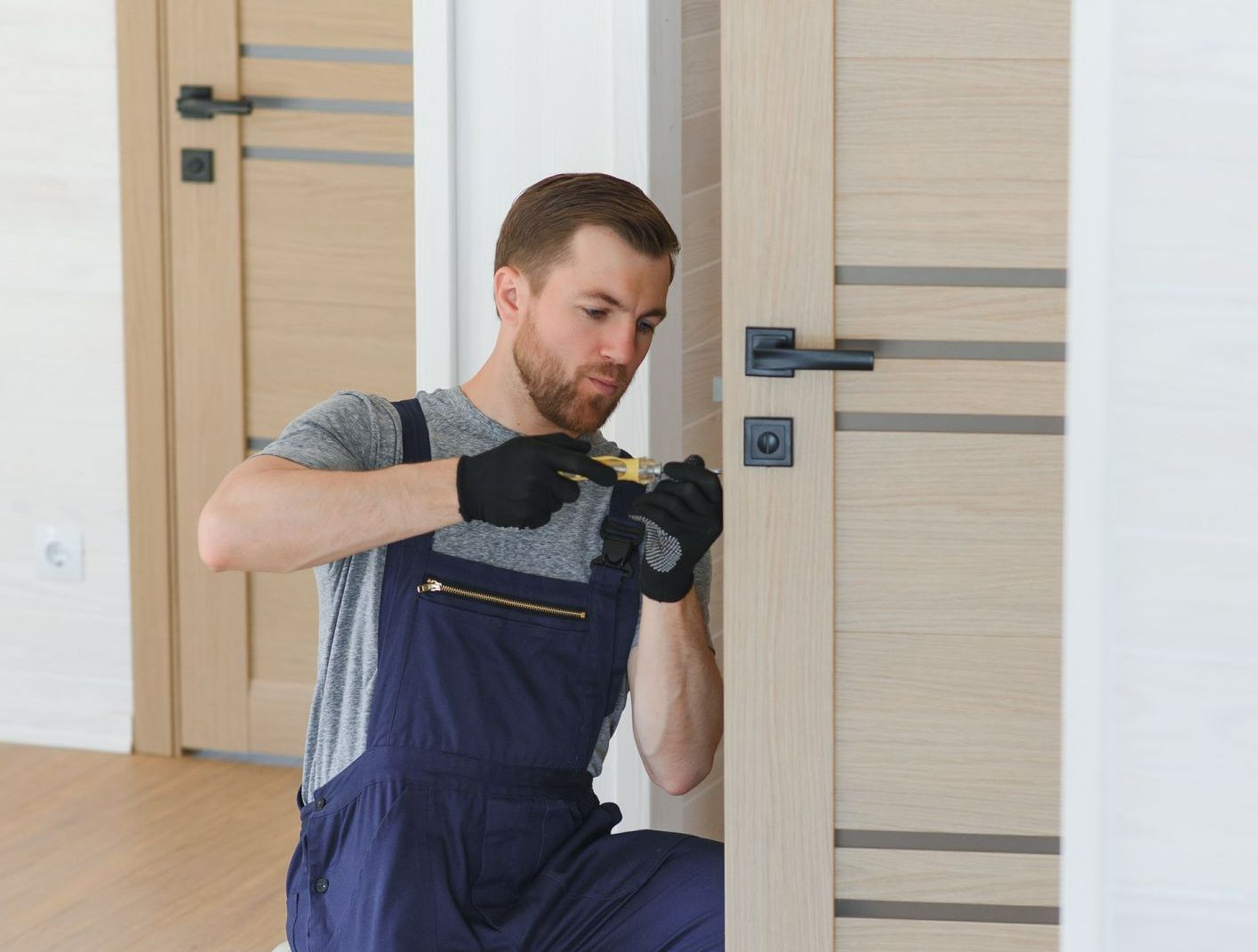 Door installation contractor fixing an interior door during a home improvement project.