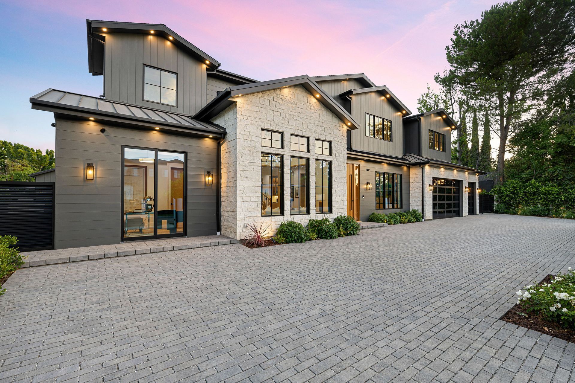 A large house with a brick driveway in front of it