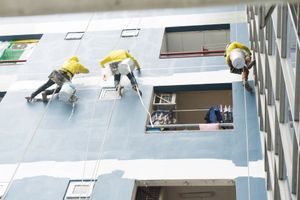 commercial painters painting the exterior of a large building