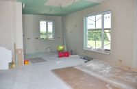 large room with drywall installation underway