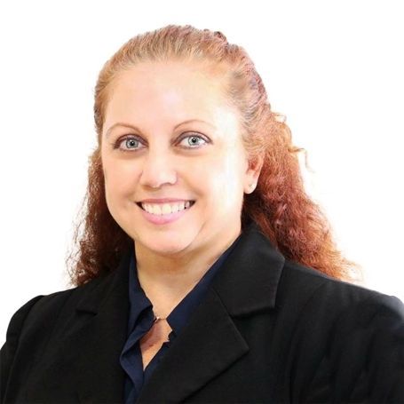 Girl in white dress crawling on sandy beach.