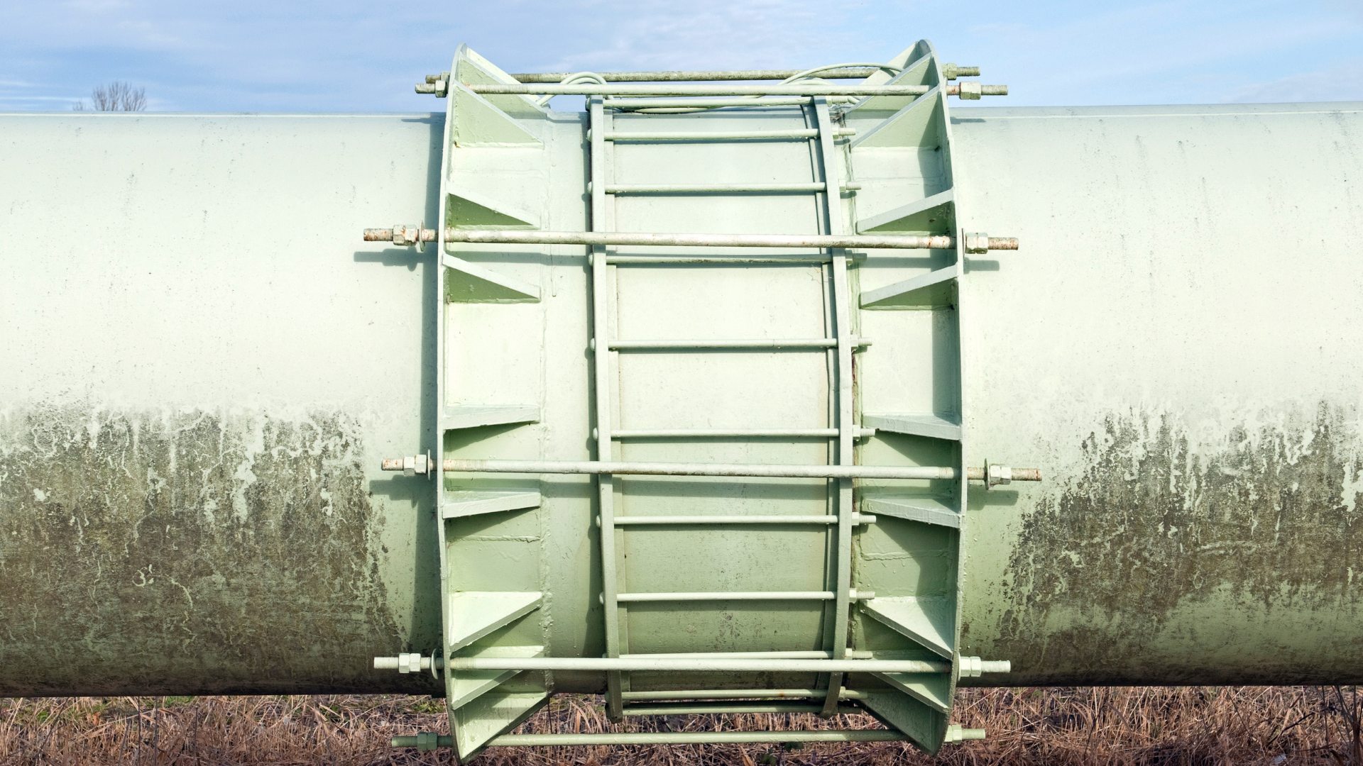 A close up of a pipe with a ladder attached to it.