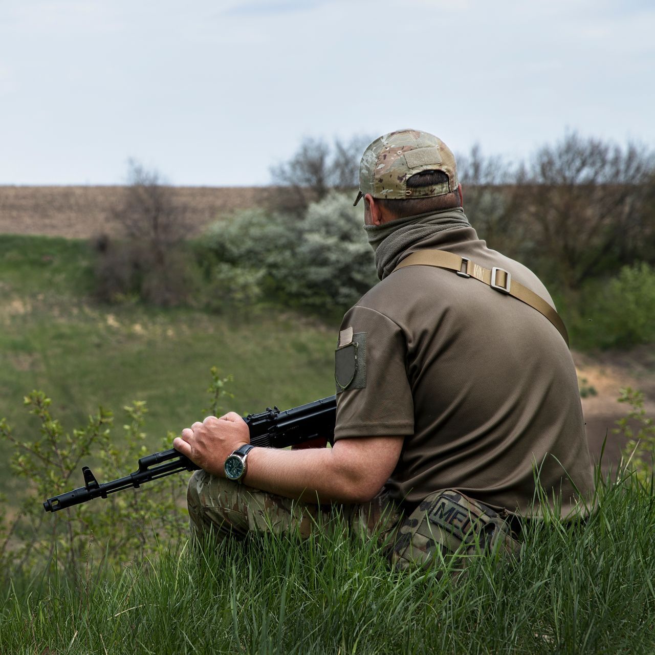 Man in the field holding a gun.