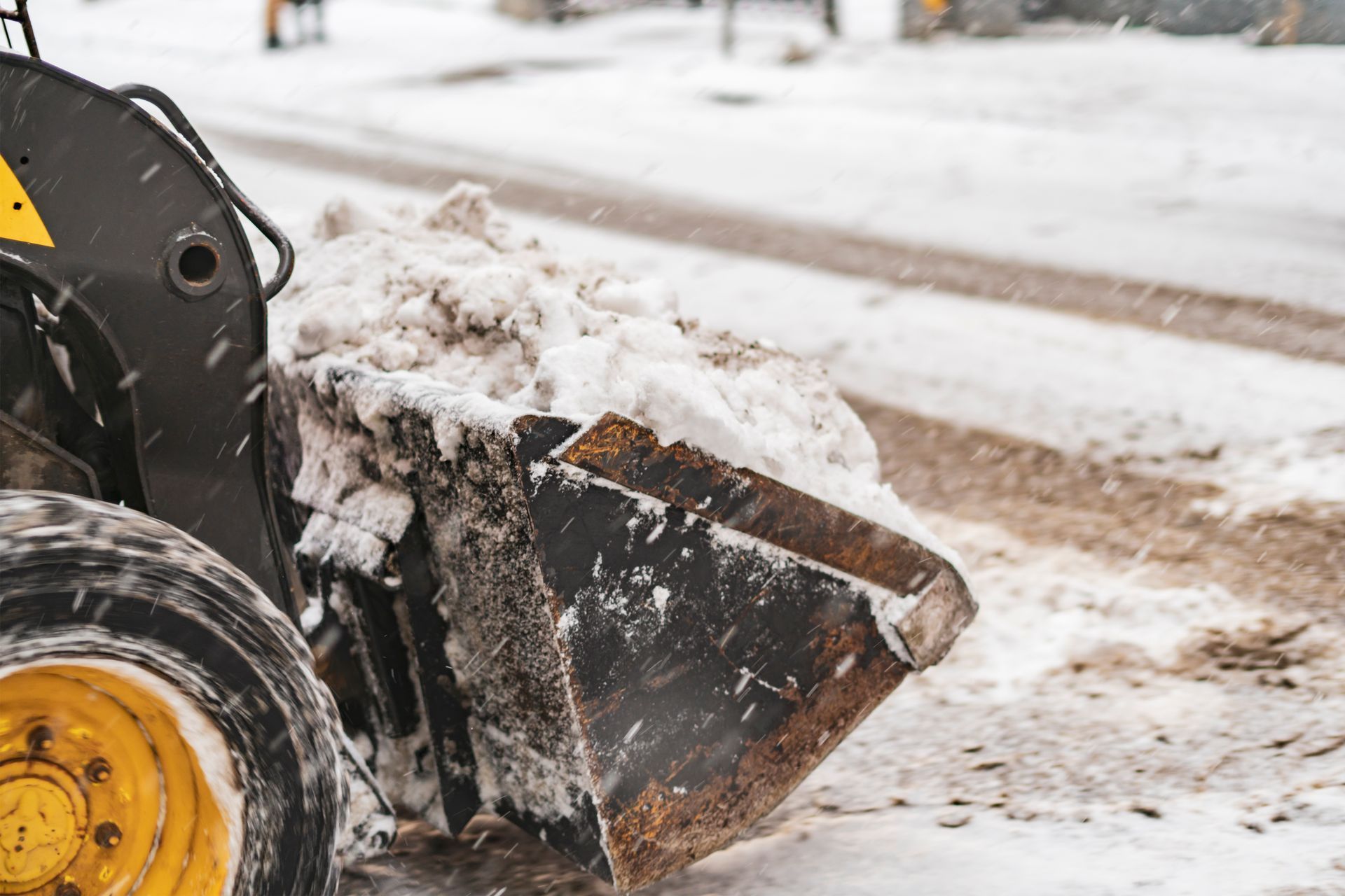 A bulldozer is clearing snow from a street.