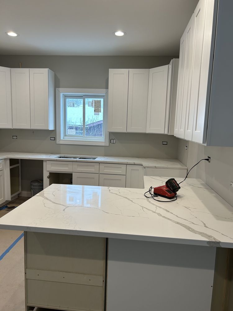 A kitchen with white cabinets and a large white counter top.